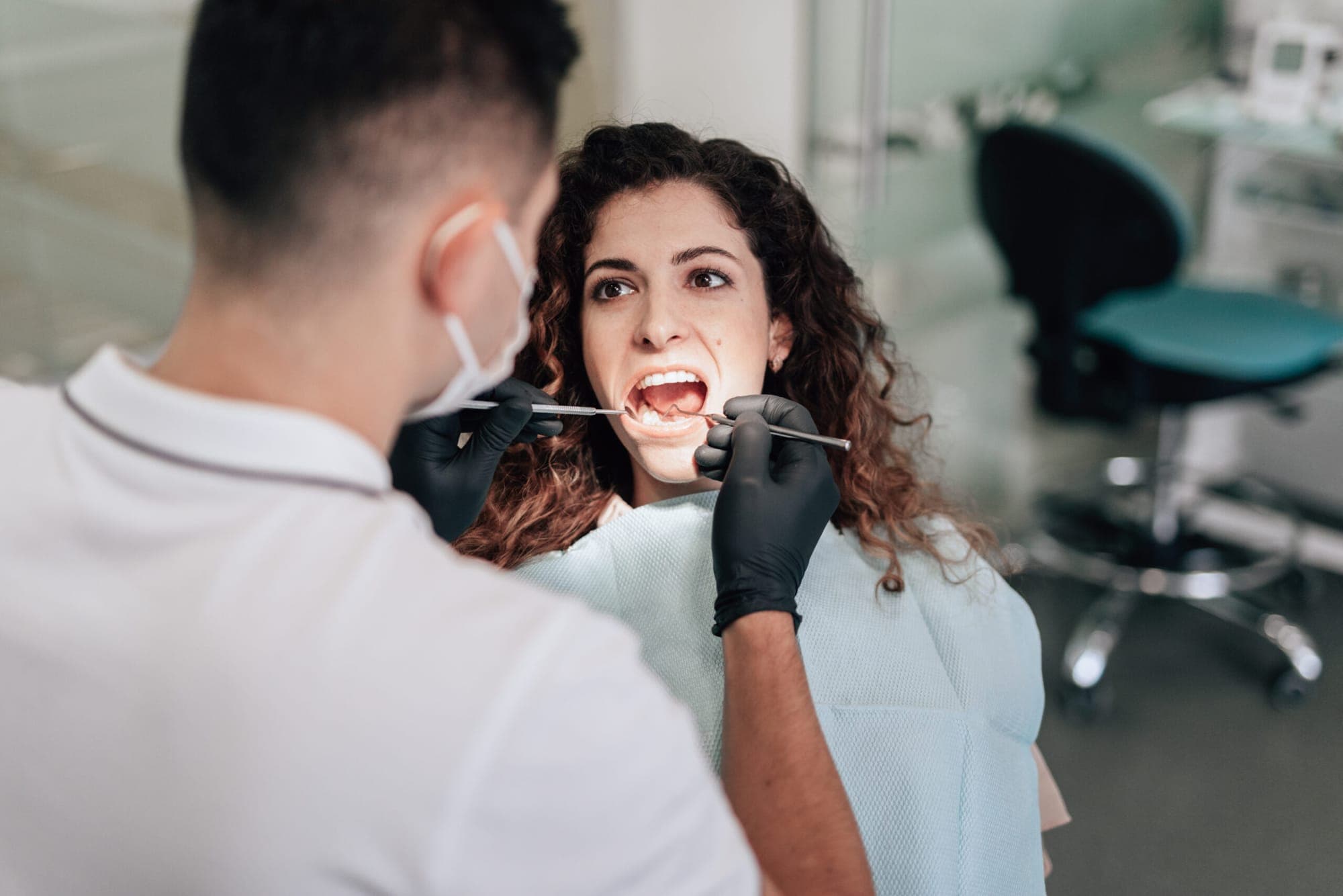 Dentist checking a patient’s gums during a routine examination