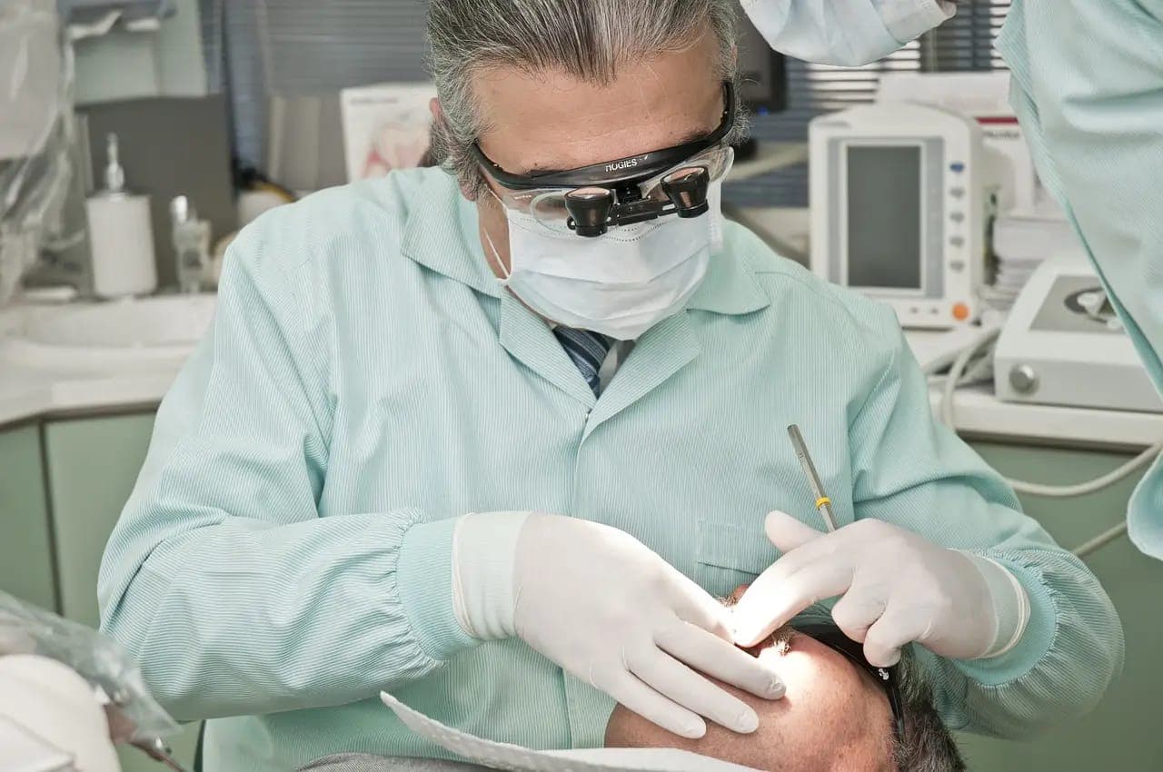 Dentist in a mask and loupes carrying out treatment